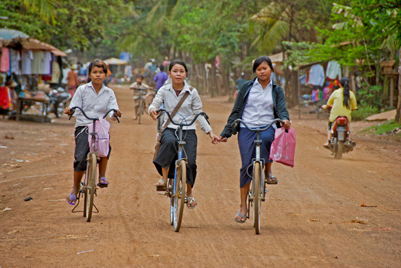 Three Girls on Bicycle in Village
