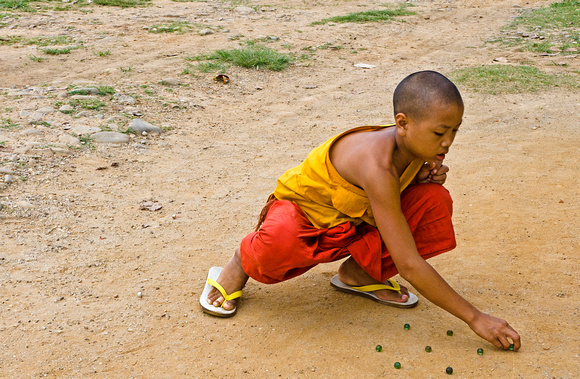 Young Monk playing marbles