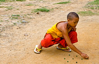 Young Monk playing marbles